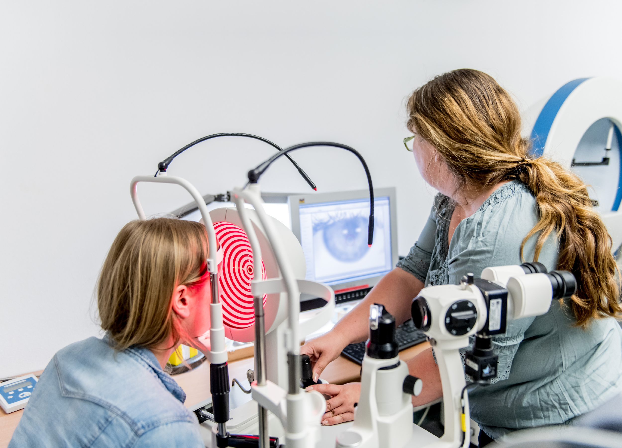 Eine Optimetristin des BFW untersucht die Hornhaut des Auges einer Frau mittels eines Keratographen.